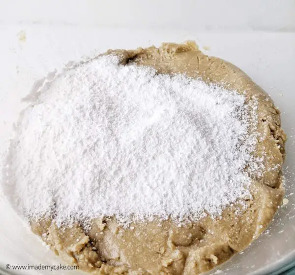 making the cookie dough by adding sugar